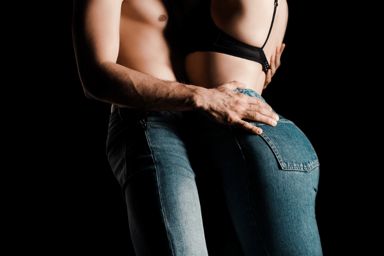 Cropped view of sexy young couple in denim jeans