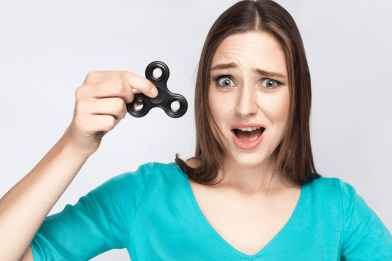 A woman holding a fidget spinner